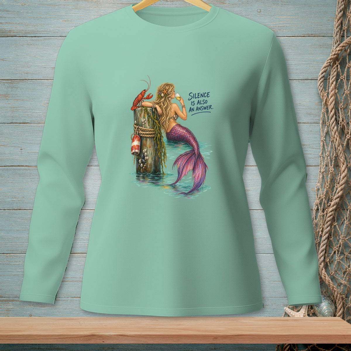 Mermaid with lobster on post, holding a drink. Text reads "Silence is also an answer."