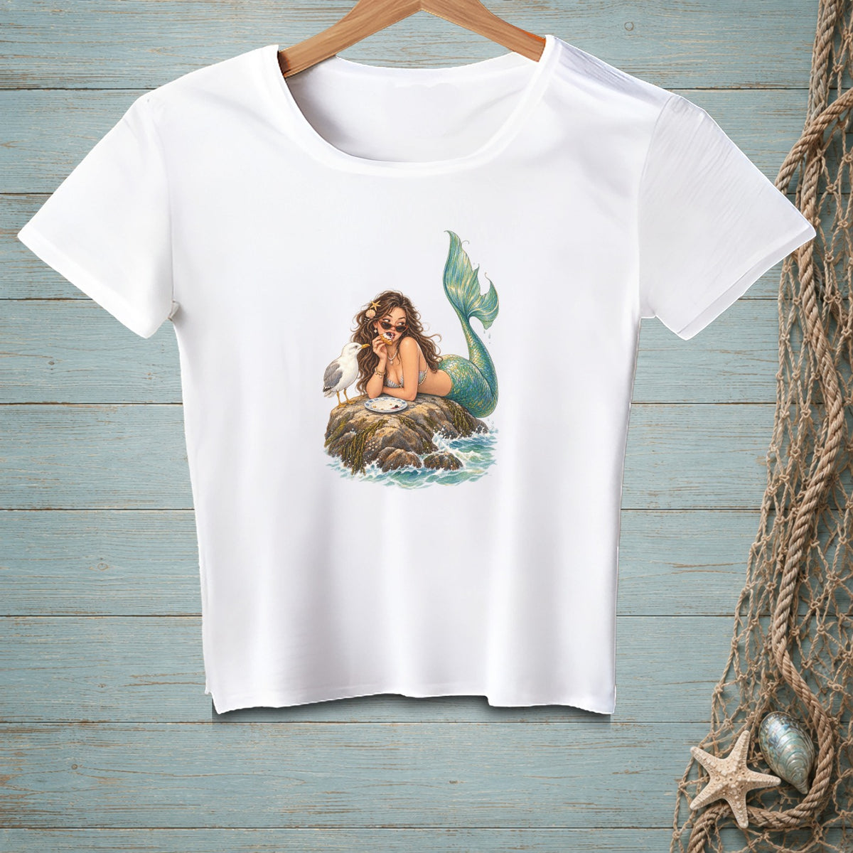 White t-shirt featuring a mermaid with a seagull on a rock.