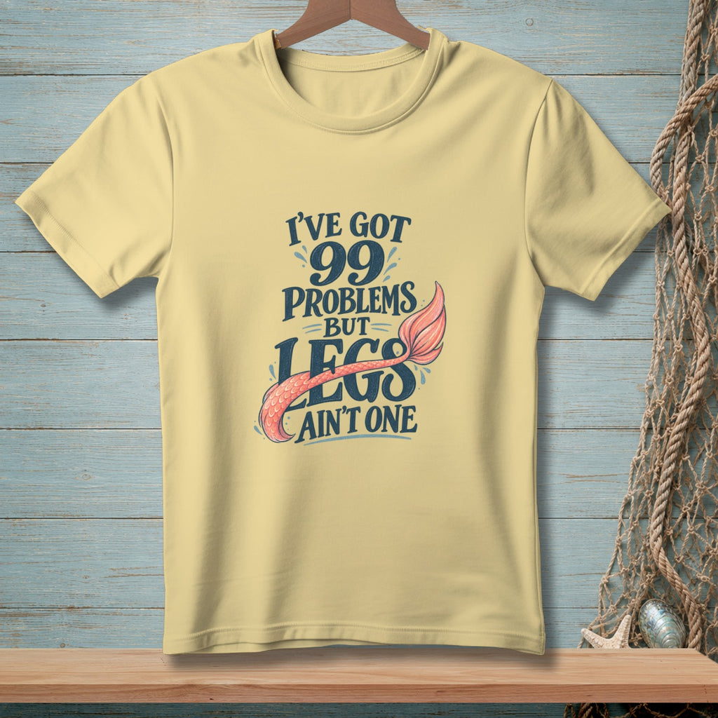 Pale yellow t-shirt with "I've got 99 problems but legs ain't one" text and mermaid tail.