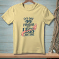 Pale yellow t-shirt with "I've got 99 problems but legs ain't one" text and mermaid tail.
