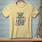Pale yellow t-shirt with "I've got 99 problems but legs ain't one" text and mermaid tail.