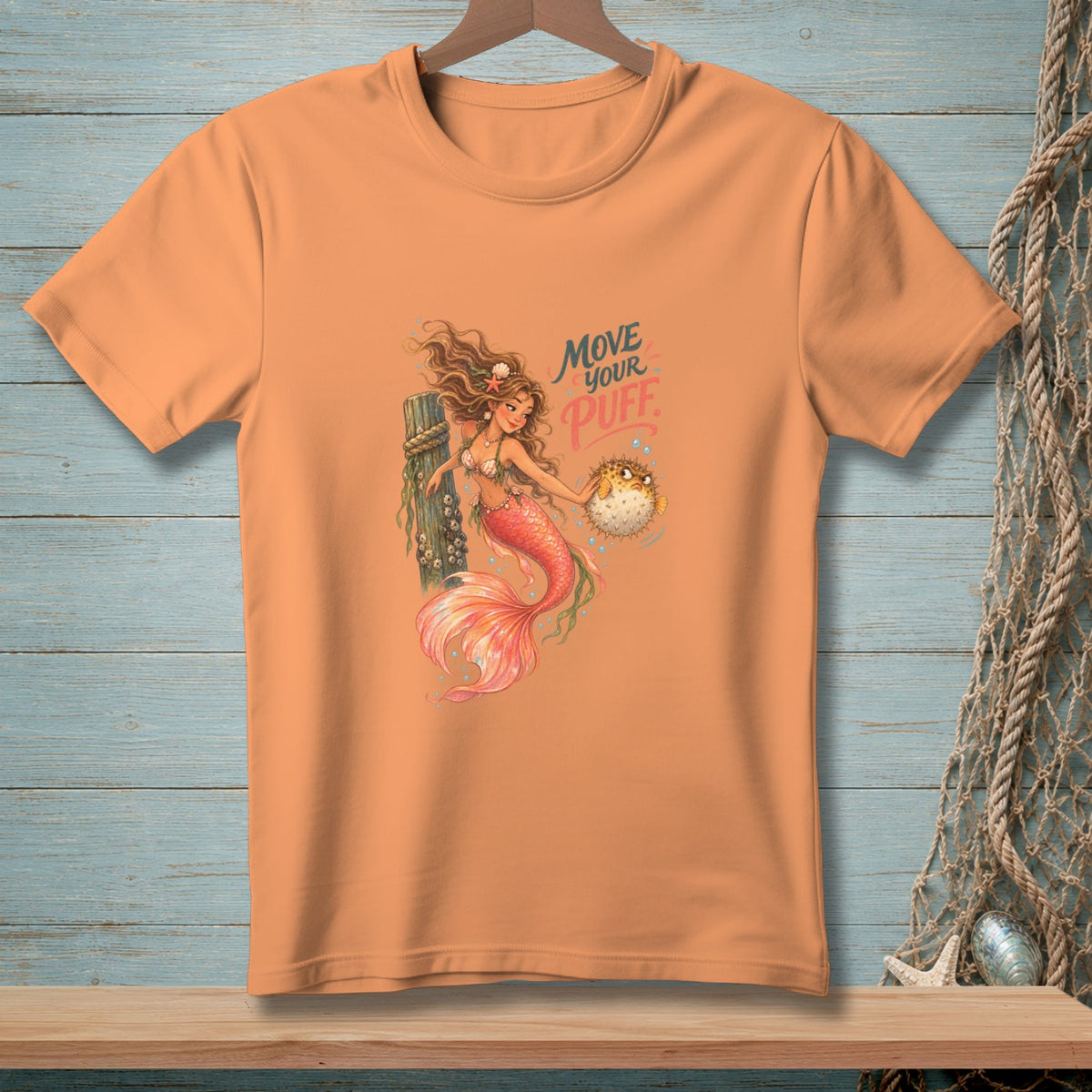Peach t-shirt with mermaid holding pufferfish graphic and text "MOVE YOUR PUFF".