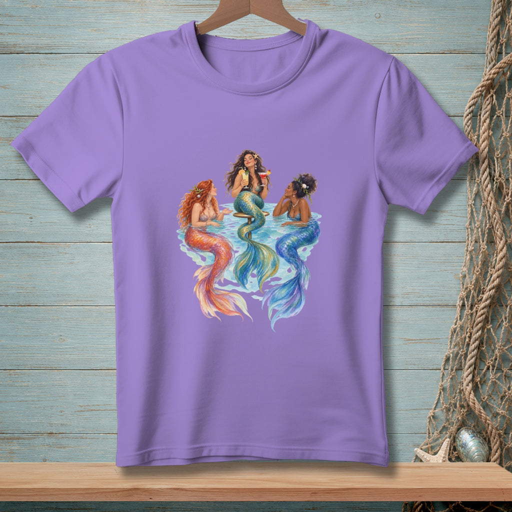 Three mermaids with colorful tails sit in water, two with drinks.