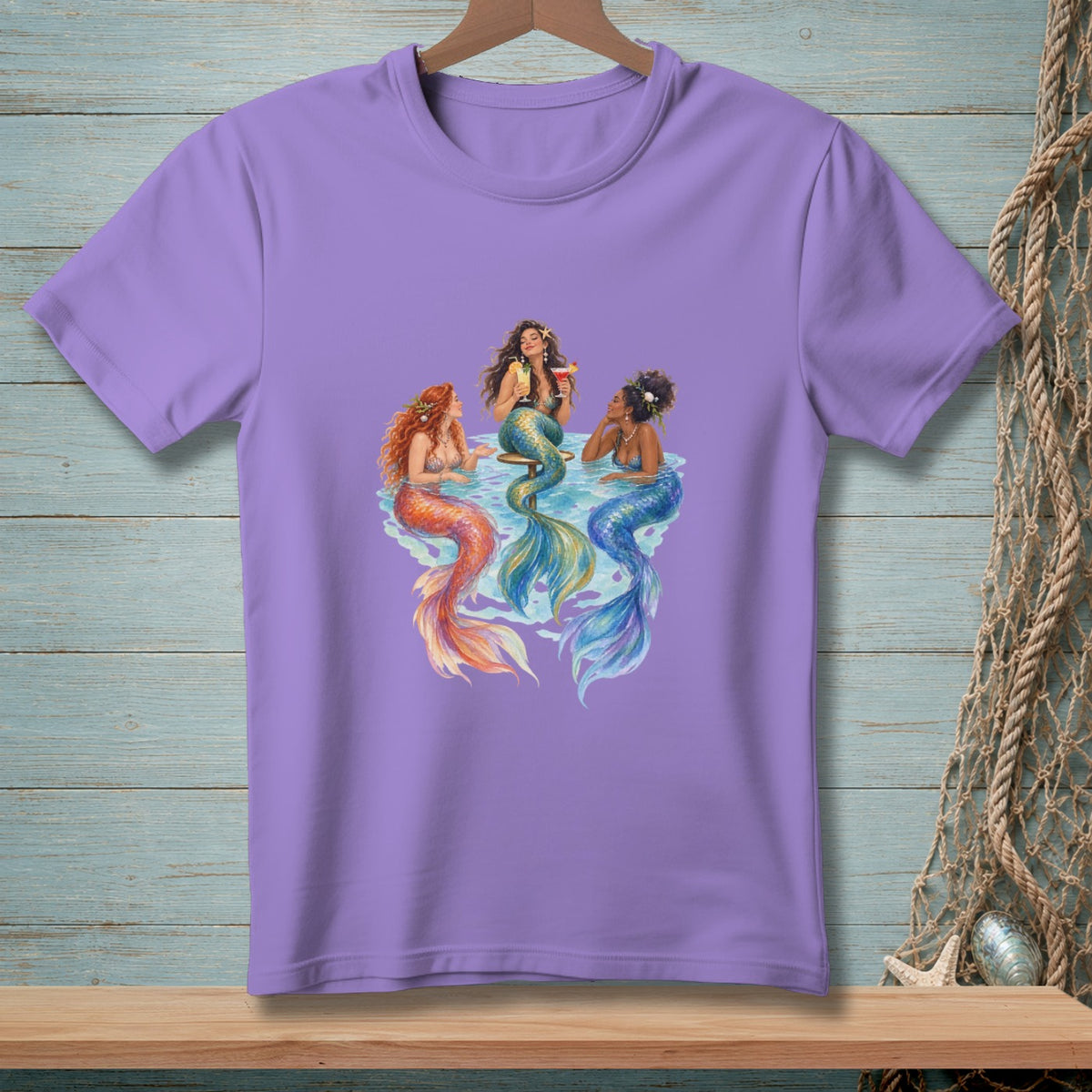 Three mermaids with colorful tails sit in water, two with drinks.