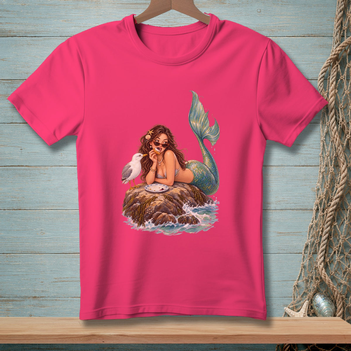 Mermaid with sunglasses eating cake on a rock with a seagull.
