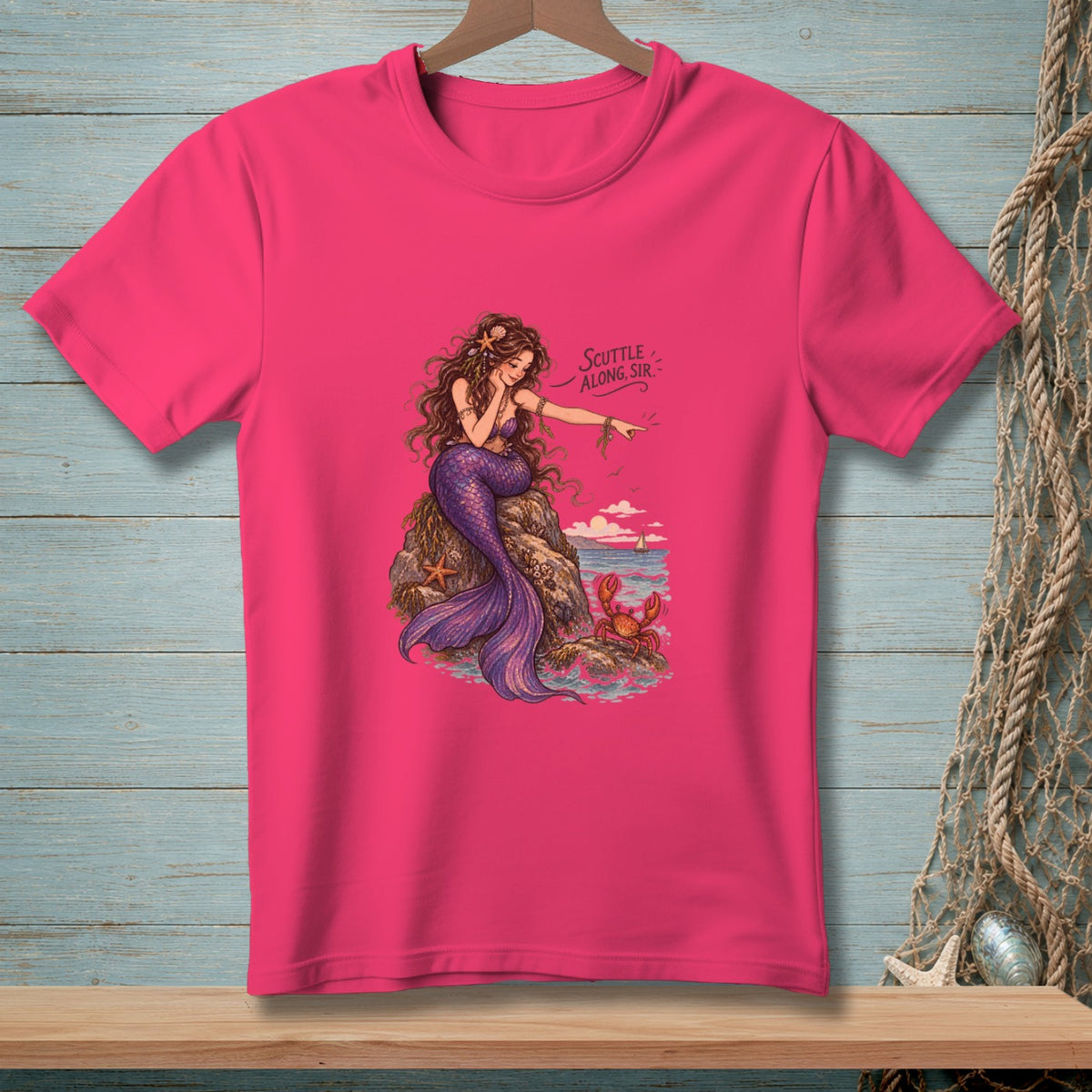Fuchsia t-shirt with a mermaid on a rock, pointing at a crab. Text reads "Scuttle Along, Sir."