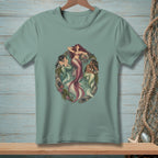 Three mermaids with colorful tails rest among rocks and seaweed in an oval design.