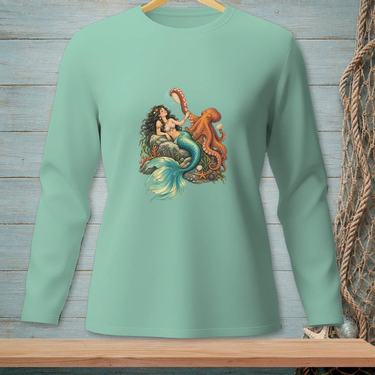Mermaid with octopus graphic on a teal long-sleeved shirt.