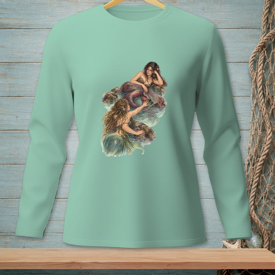 Mint green long-sleeved shirt featuring an illustration of two mermaids on rocks.
