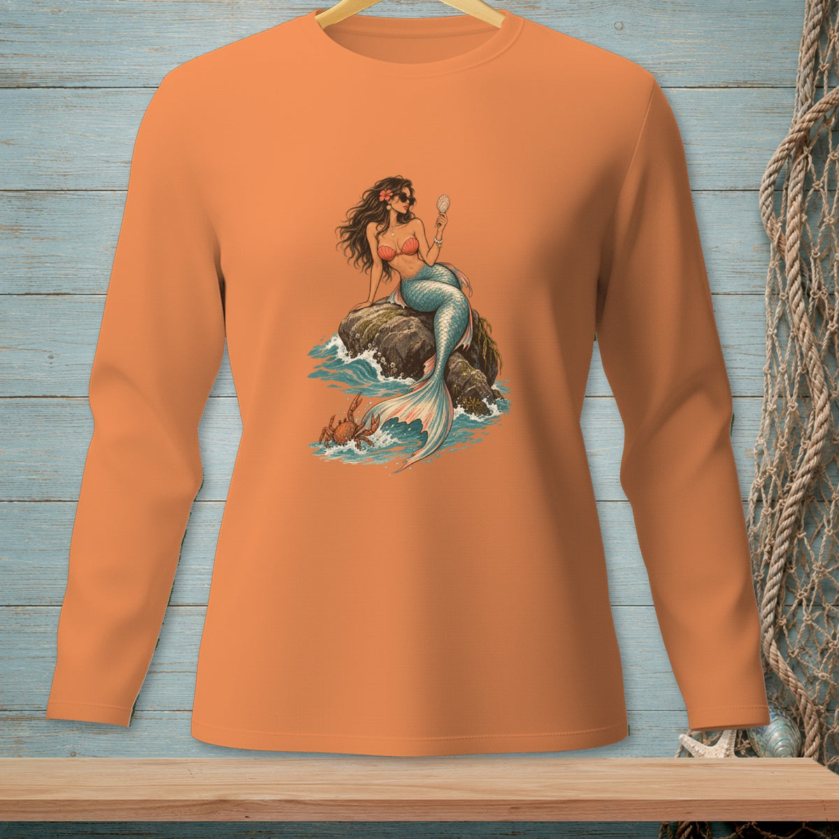 Long-sleeve orange shirt with a mermaid sitting on a rock, holding a mirror, with a crab nearby.
