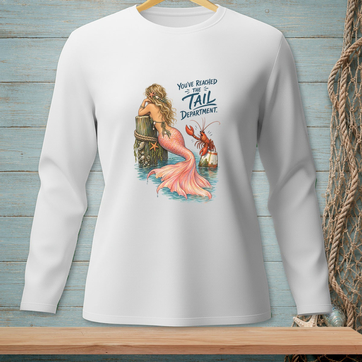 White long-sleeved shirt with a graphic of a mermaid and lobster, reading "You've Reached the Tail Department."