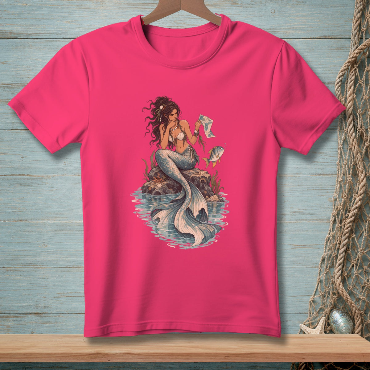 Illustration of a mermaid with a fish on a pink t-shirt.