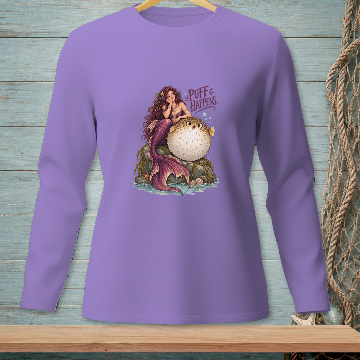 Purple long-sleeve shirt with a mermaid and pufferfish graphic that says "Puff Happens."