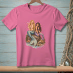 Two mermaids sitting on rocks with a pearl and a basket of shells.
