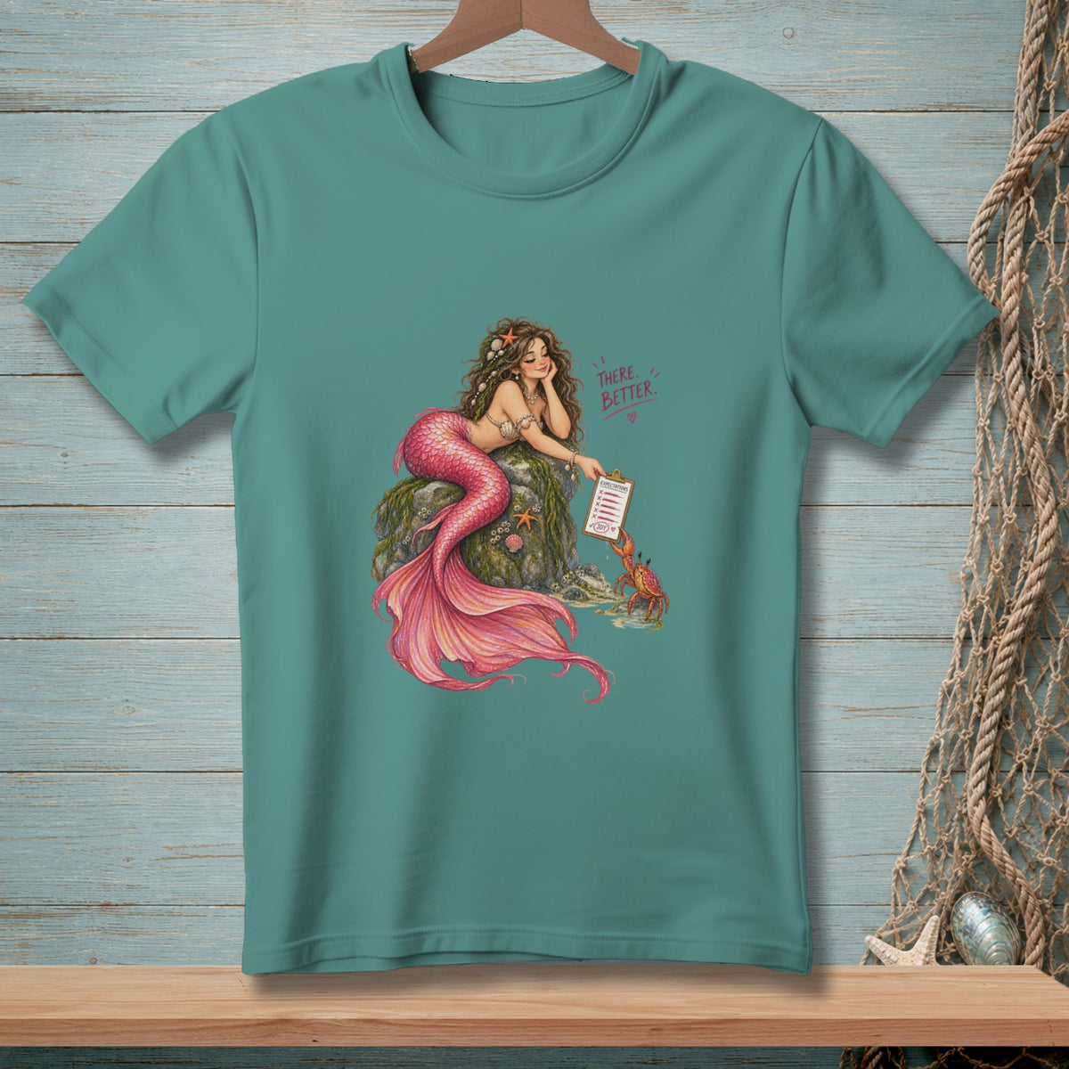 Teal t-shirt with a mermaid and crab graphic featuring text "THERE. BETTER."