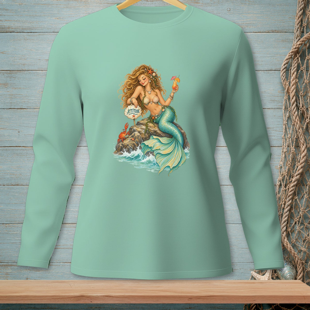 Mint long-sleeve shirt with a mermaid holding a drink and a sign reading "Attitude".