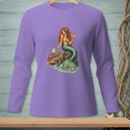 Mermaid with a cocktail and crab reading on a rock, printed on a purple long-sleeve shirt.