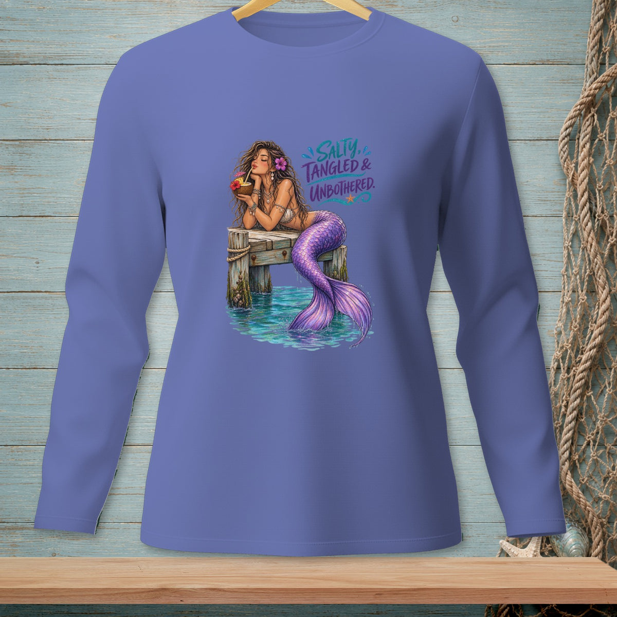 Mermaid on pier drinking from coconut, with "Salty, Tangled & Unbothered" text.