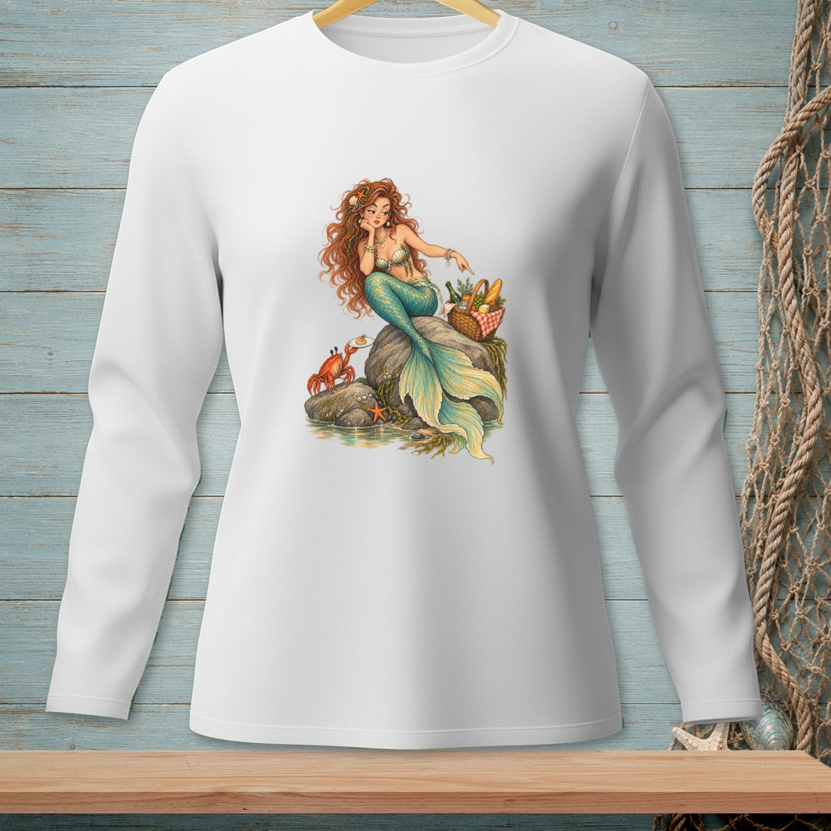 Mermaid with red hair sits on a rock with a crab and picnic basket.