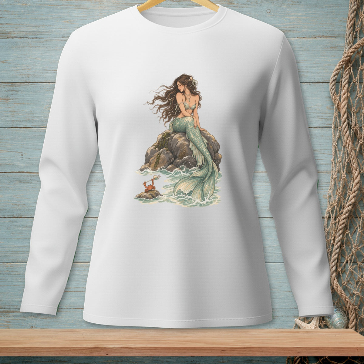 Long-sleeved white shirt with a mermaid and crab graphic on a rock.