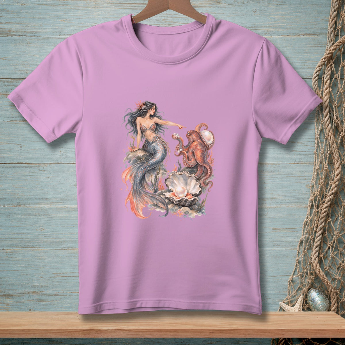 Pink t-shirt with a watercolor illustration of a mermaid, octopus, and a large seashell.