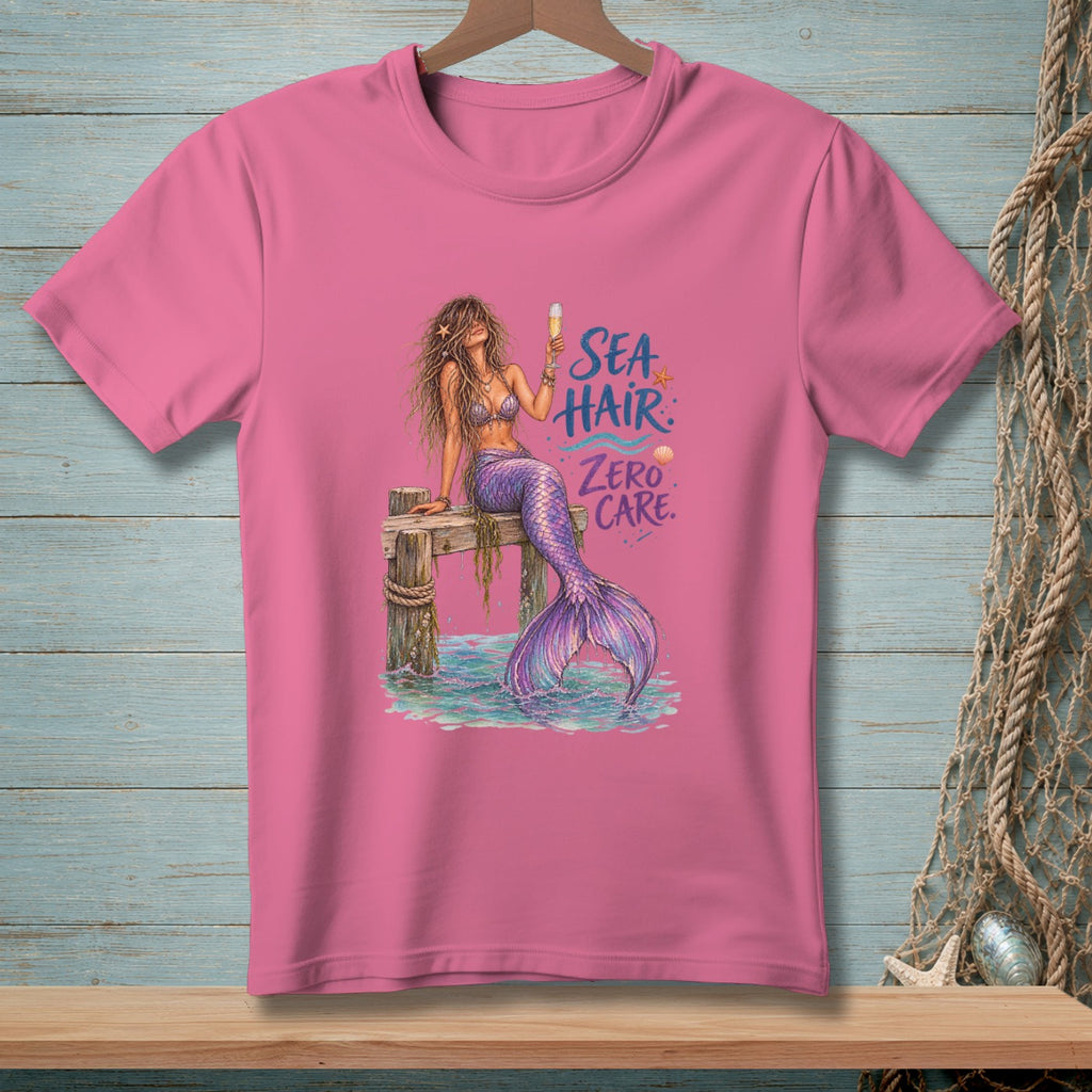 Pink t-shirt with mermaid illustration and text "Sea Hair Zero Care".