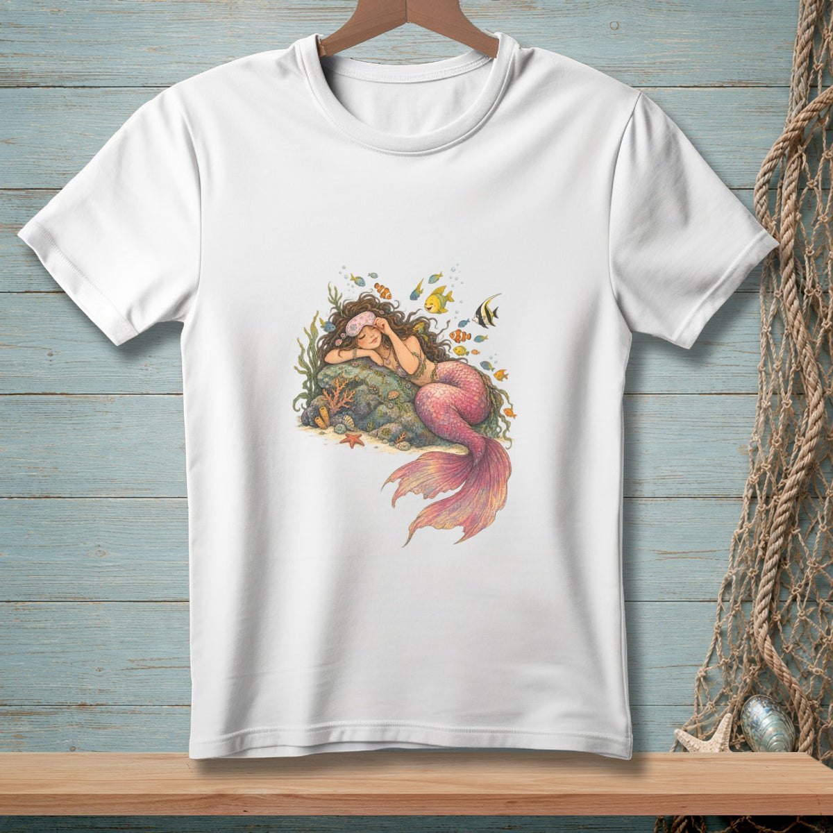 Illustration of a sleeping mermaid with a pink tail surrounded by colorful fish and coral.