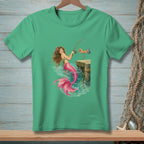 Green t-shirt with a mermaid fishing from a dock in turquoise water.