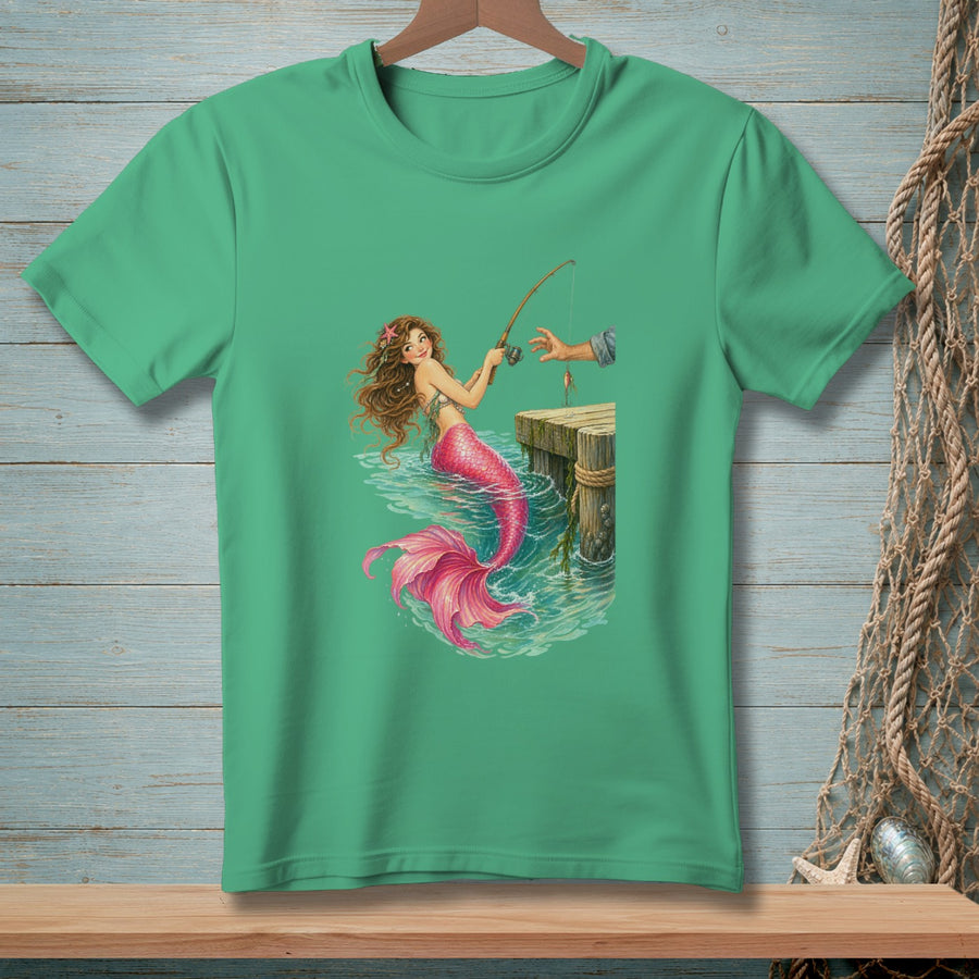 Green t-shirt with a mermaid fishing from a dock in turquoise water.
