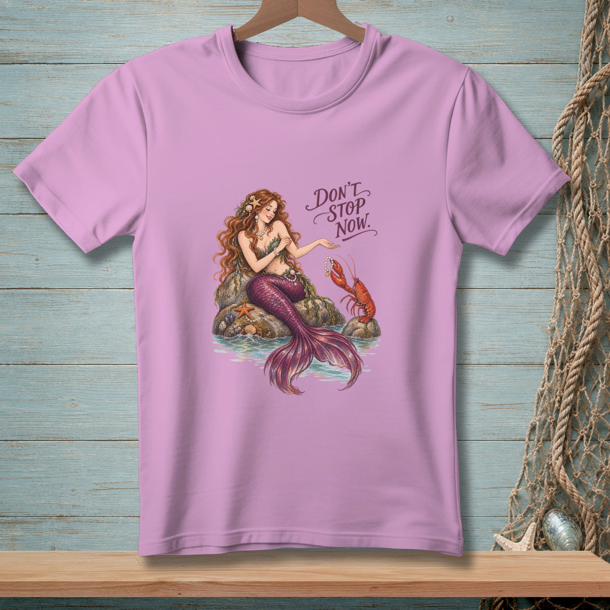 Mermaid sitting on rocks with a lobster, text reads "Don't Stop Now."