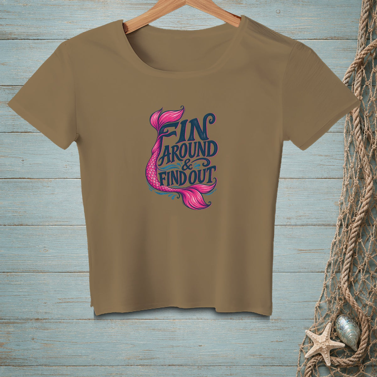 Brown t-shirt with pink mermaid tail and "FIN AROUND & FIND OUT" text.