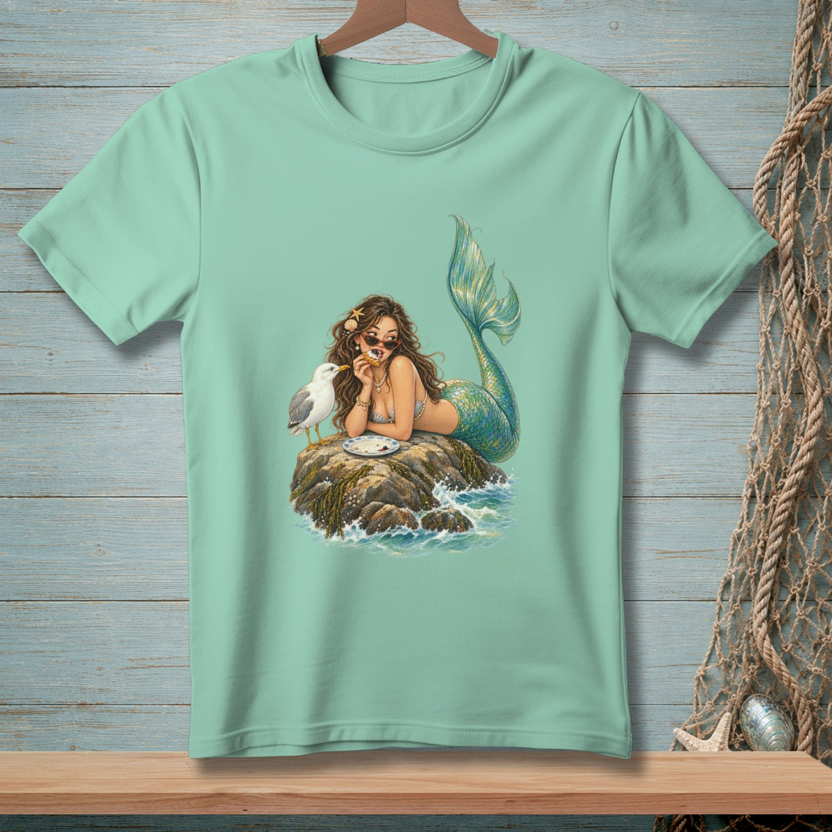 Illustration of a mermaid eating with a seagull on a rock.