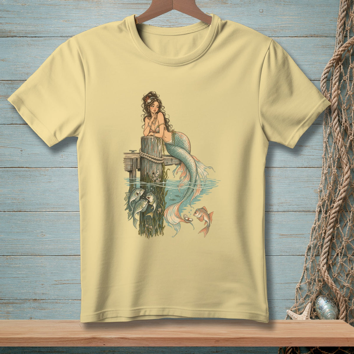 Pale yellow t-shirt with a vintage mermaid and fish illustration.