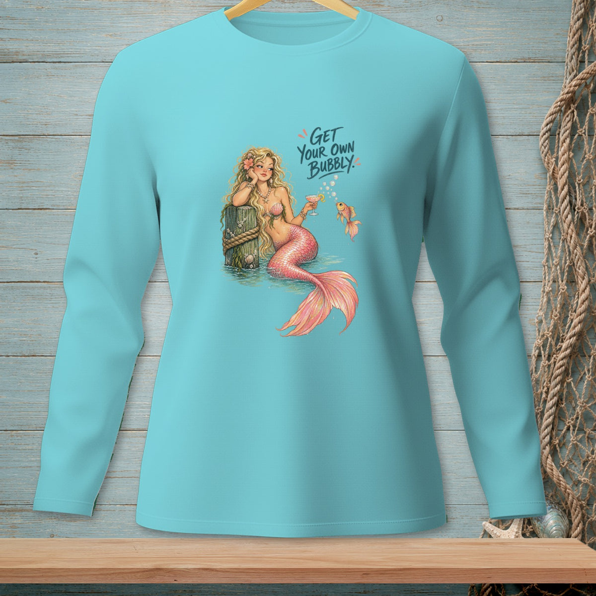 Turquoise long-sleeve shirt with a mermaid, fish, cocktail, and "Get Your Own Bubbly" text.