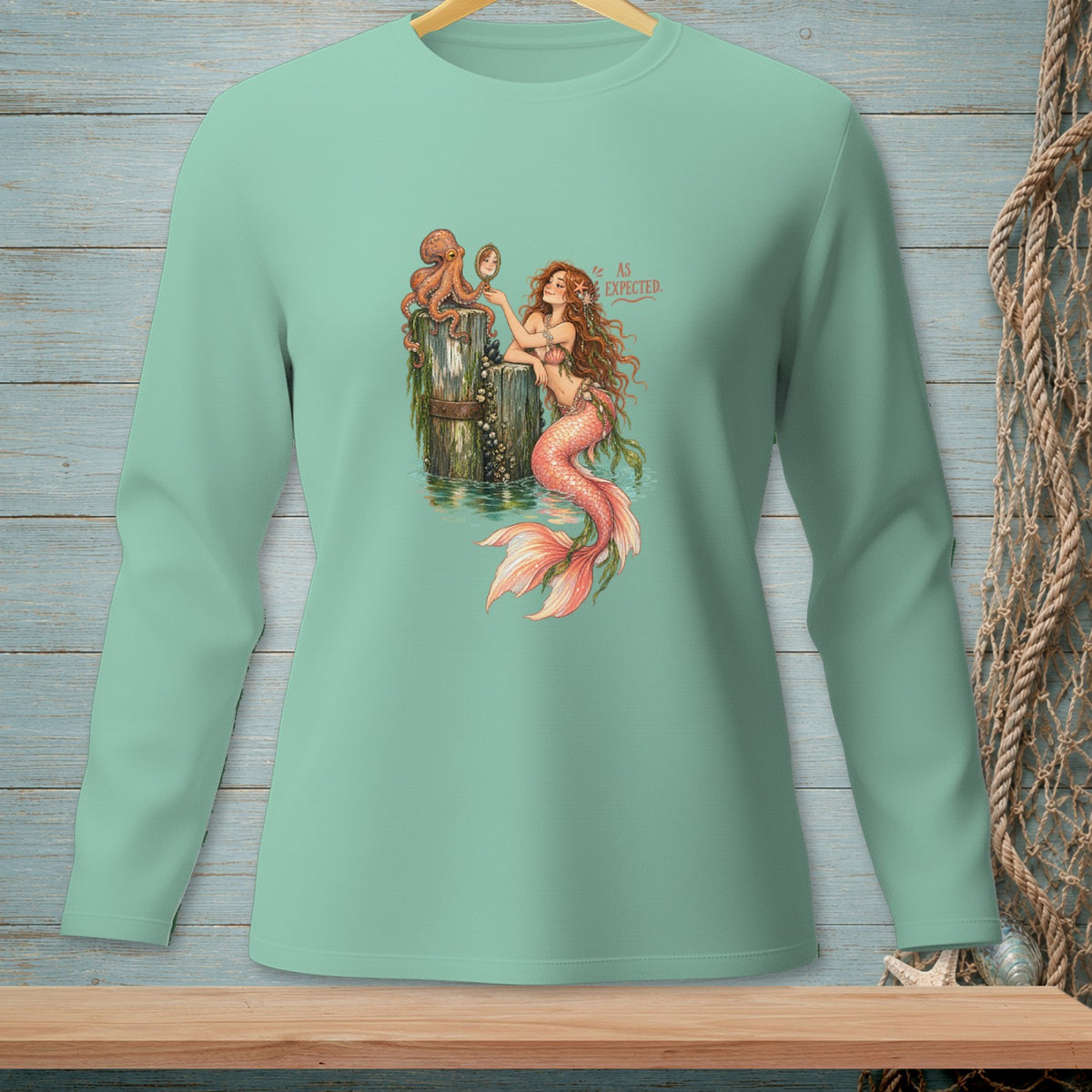 Mermaid with octopus admiring reflection in a mirror, text "As Expected."