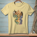Three mermaids sit at a table on a dock, with a bottle of champagne and drinks.