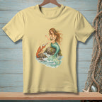 Cream t-shirt with mermaid and lobster illustration on a rock by the sea.