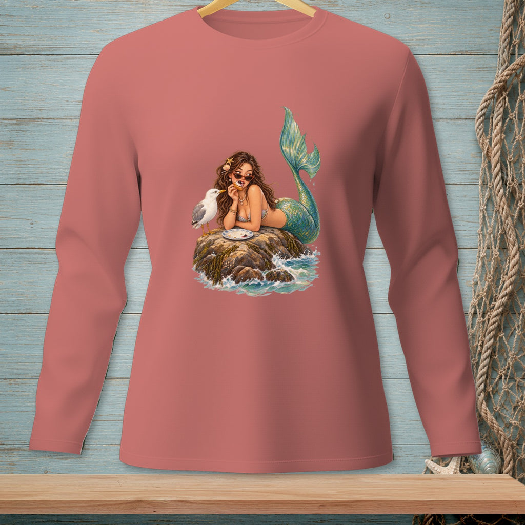 Mermaid on rock with seagull eating pastry, on a coral long-sleeved shirt.