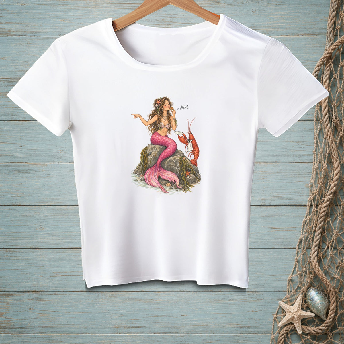 White t-shirt with a mermaid and lobster graphic, text "Next".