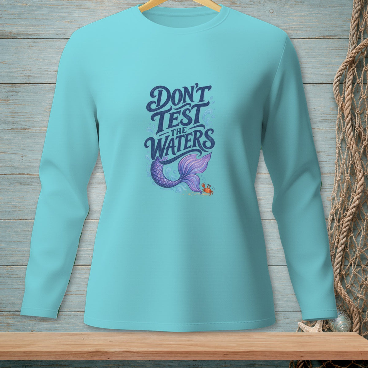 Long sleeve teal t-shirt with "Don't Test The Waters" and mermaid tail graphic.