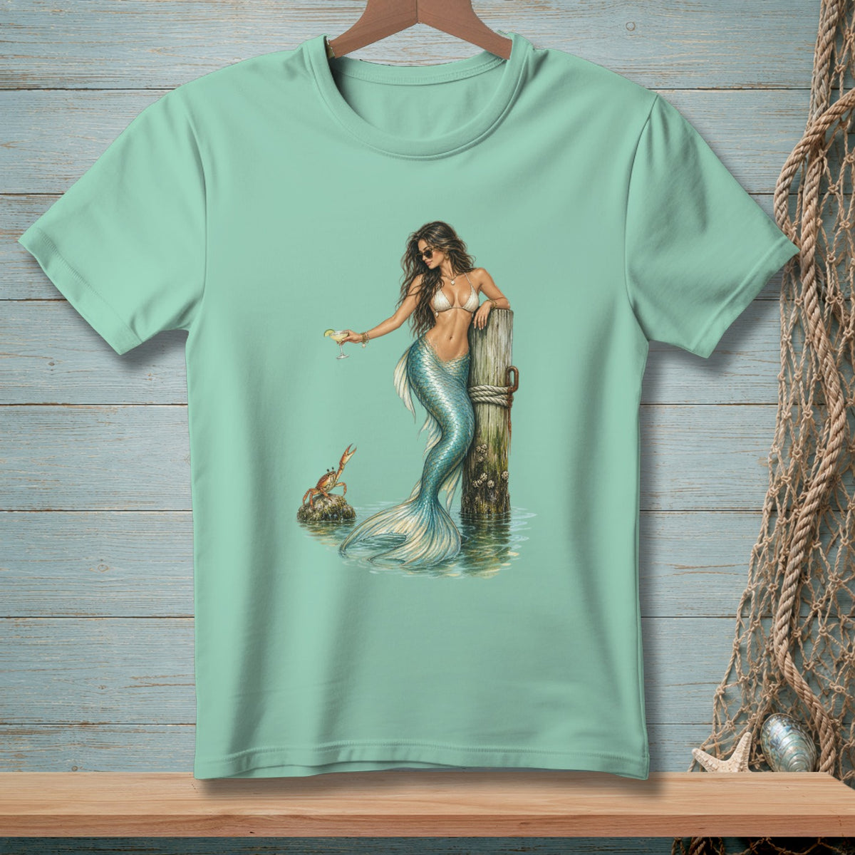 Mermaid with cocktail and crab by a wooden post, graphic design on t-shirt.