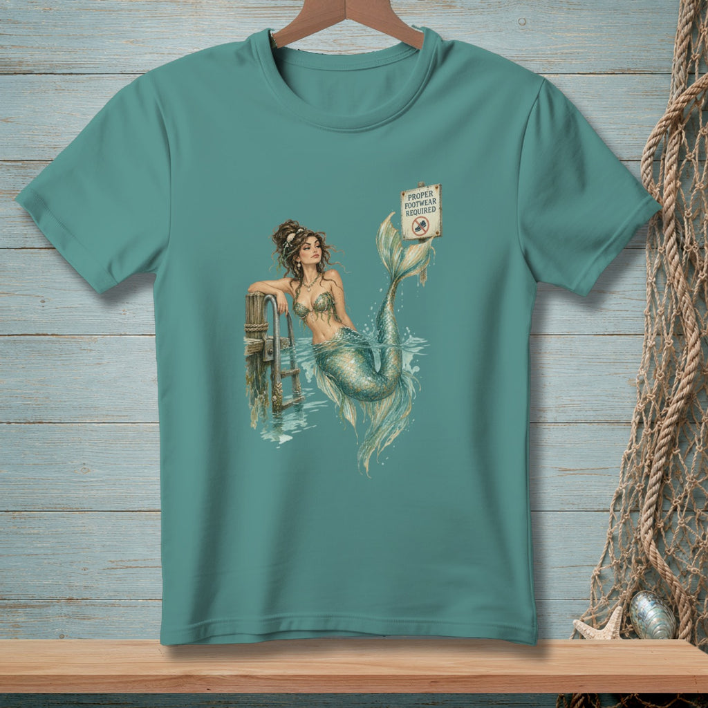 Mermaid leaning on dock with "Proper Footwear Required" sign.