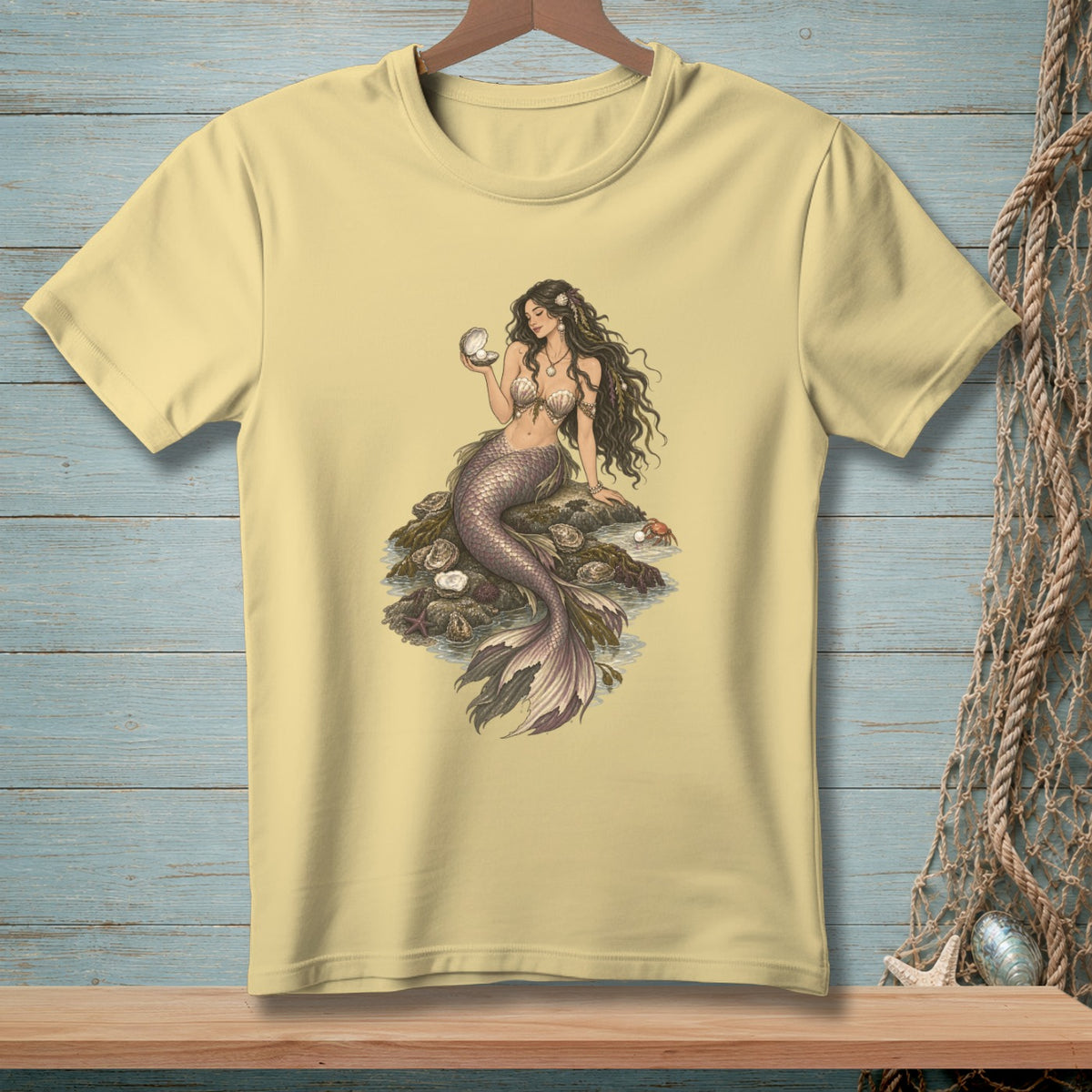 Pale yellow t-shirt with a detailed illustration of a mermaid holding a pearl.