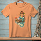 Peach t-shirt with a graphic of a mermaid, crab, starfish, and cocktails on rocks.