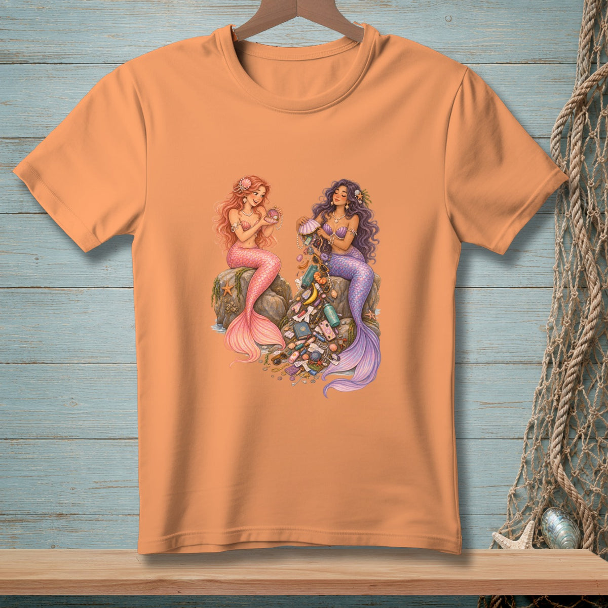 Two mermaids sitting on rocks surrounded by scattered trash and seashells.