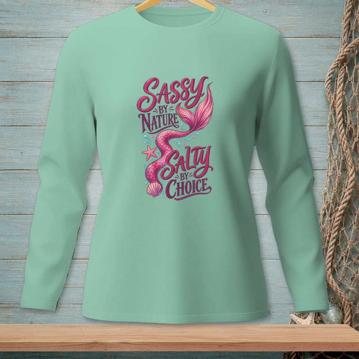 Mint green long-sleeve shirt with pink mermaid graphic and text.
