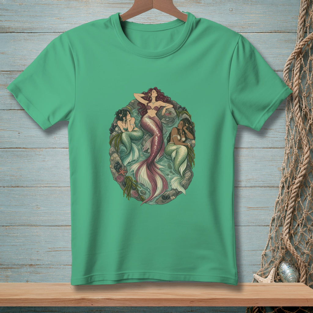 Three mermaids are depicted within a circular, underwater scene on a teal t-shirt.