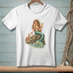 White t-shirt with a graphic of a mermaid on a rock holding a drink and a crab nearby.