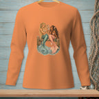 Two mermaids sit on a wooden pier, one holding a seashell mirror.