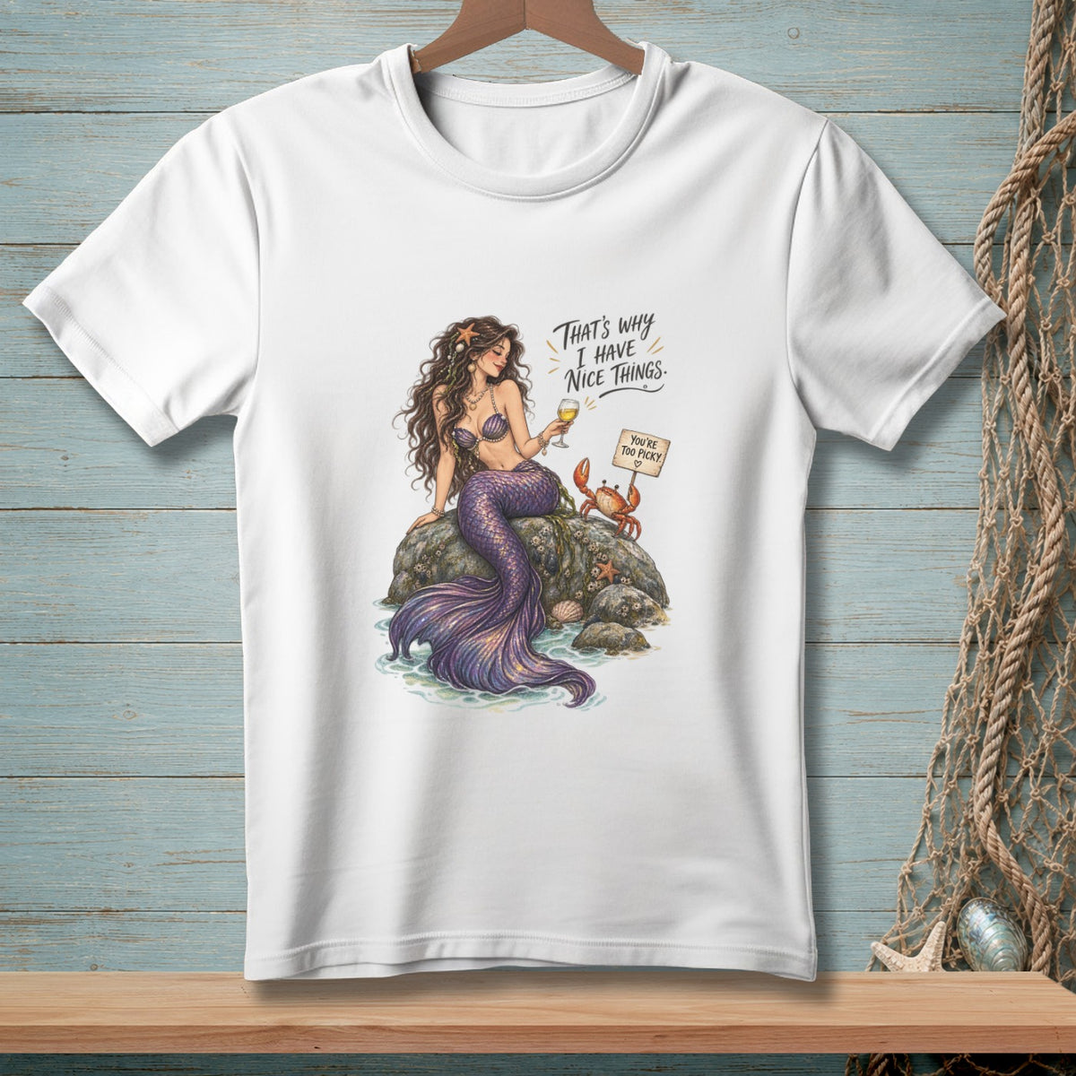 White t-shirt with mermaid, crab, and sign reading "That's why I have nice things."
